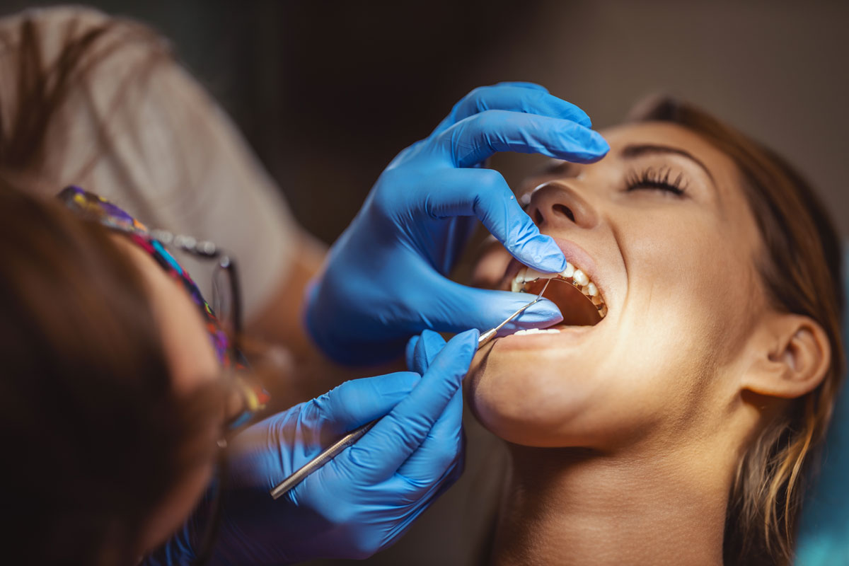 dentista che applica l'apparecchio linguale a una donna